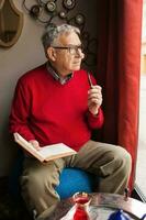 A senior man in a red sweater relaxing photo