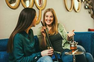 Friends spending time together and smoking hookah photo