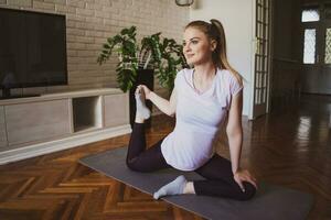 joven mujer practicando pilates y yoga ejercicios a hogar foto