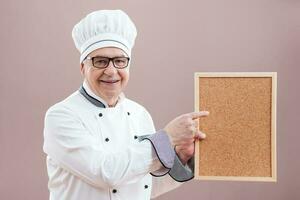 A chef pointing to a display photo