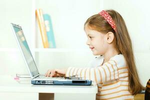 un niña utilizando un ordenador portátil foto