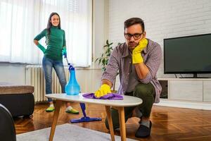 Young couple is exhausted from cleaning their apartment photo
