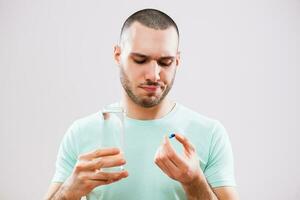 A man with green tshirt taking his medication photo