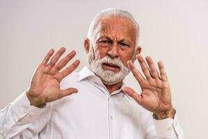 Portrait of a scared senior man in a white shirt photo