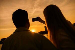 un joven Pareja terminado el puesta de sol foto