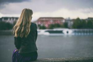 A young woman alone by a bridge photo