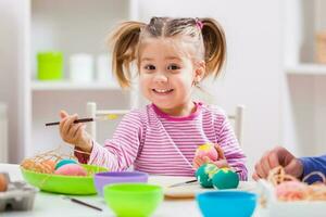 A young girl painting Easter eggs photo
