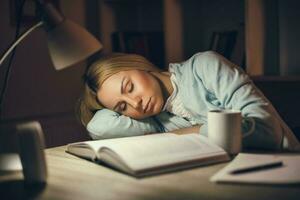 Tired college girl studying late night at home photo