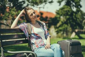 Young tourist woman sitting on the park photo