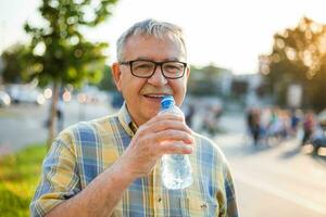 un mayor hombre Bebiendo agua foto