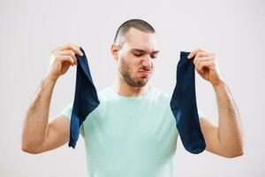 A man with green tshirt holding a sock photo