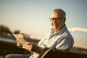 Senior man reading a book outside photo