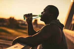 un africano americano hombre Bebiendo agua foto