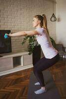 Young woman doing physical exercises at home photo