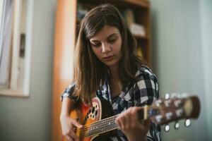 A teenage girl playing guitar photo