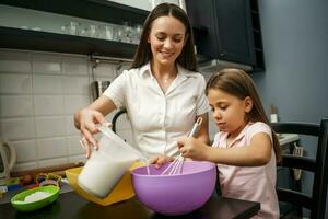 Mother and daughter cooking together photo