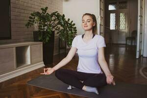 Young woman practicing pilates and yoga exercises at home photo