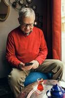 A senior man in a red sweater relaxing photo