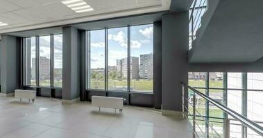 loop rotation and panoramic view in empty modern hall with stairs, columns, doors and panoramic windows overlooking the city. video