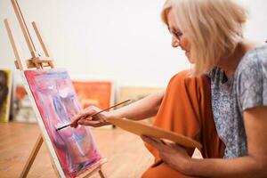 A senior woman painting photo