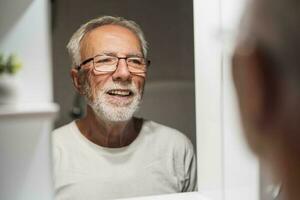 A senior man looks in the mirror photo