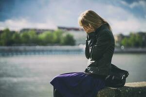 A young woman is upset and crying outdoors photo
