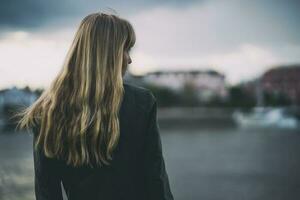 A young woman alone by a bridge photo