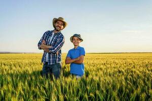 Father and son standing in a wheat field photo