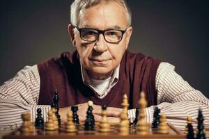 A senior man playing chess photo
