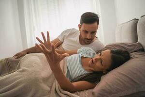 A young couple lying in bed and having a discussion photo