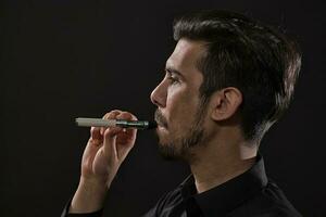 un hombre de fumar un electrónico cigarrillo foto