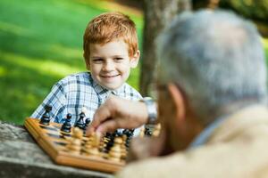 un abuelo y su nieto jugando ajedrez foto