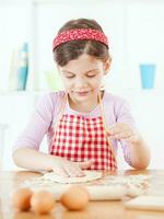 un joven niña Cocinando foto