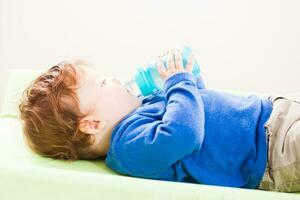 un pequeño niño Bebiendo agua foto