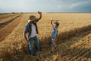 Father and son are standing in their wheat field photo