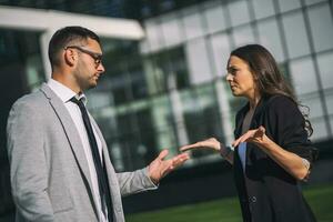 Business colleagues are arguing outside the company building. photo