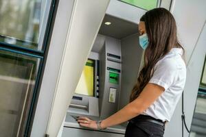 A woman using an ATM photo