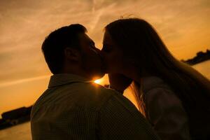 un joven Pareja terminado el puesta de sol foto