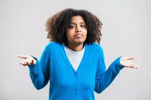 Portrait of doubtful Afro woman with a blue cardigan photo