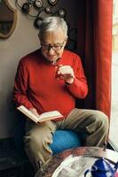 A senior man in a red sweater relaxing photo