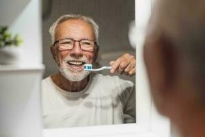A senior man brushes his teeth photo