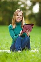 A woman spending time outdoors with a tablet device photo