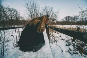 Sad young blonde woman on the forest photo