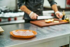 un cocinero es preparando un comida en el restaurante cocina. foto