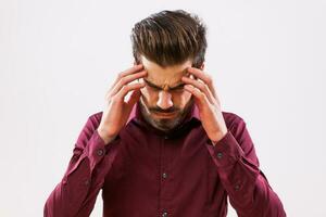 un hombre en un púrpura camisa con un dolor de cabeza foto