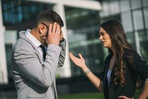 Business colleagues are arguing outside the company building. photo