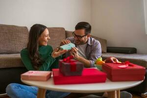 Couple exchanging gifts in their home photo