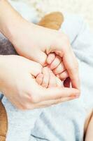 A woman holding her baby hands photo