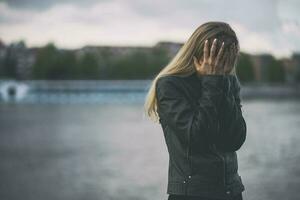 A young woman is upset and crying outdoors photo