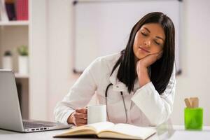 Female doctor working in her office photo